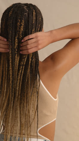 Foto-De-Estudio-De-Vista-Trasera-De-Una-Mujer-Joven-Con-Cabello-Largo-Trenzado-Sintiendo-Suavidad-Después-Del-Producto-Para-El-Cuidado-Del-Cabello